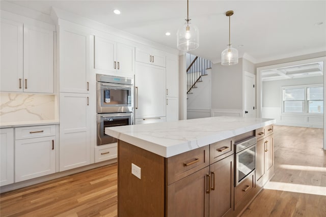 kitchen with white cabinetry, coffered ceiling, and stainless steel double oven