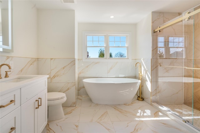 full bathroom featuring vanity, shower with separate bathtub, and toilet