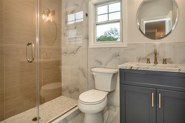 bathroom featuring vanity, toilet, a shower with shower door, and tile walls