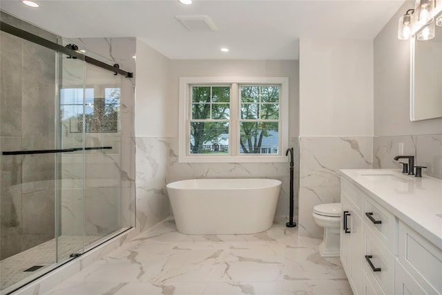 full bathroom featuring vanity, toilet, and separate shower and tub