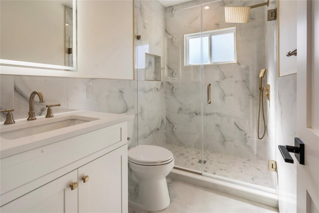 bathroom with a shower with door, tile walls, vanity, tasteful backsplash, and toilet