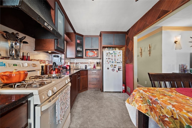 kitchen with tasteful backsplash, sink, white appliances, and custom exhaust hood