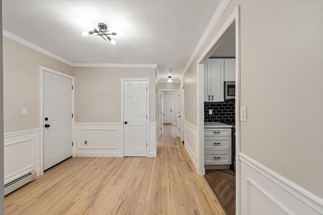 corridor featuring crown molding, light wood-type flooring, and baseboard heating