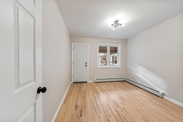 spare room with baseboard heating and light wood-type flooring