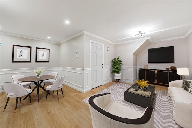 living room with ornamental molding and light hardwood / wood-style flooring