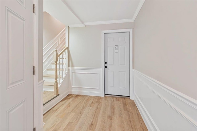 entryway with light hardwood / wood-style flooring and ornamental molding