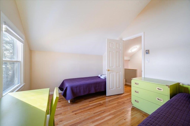 bedroom with lofted ceiling and light hardwood / wood-style floors