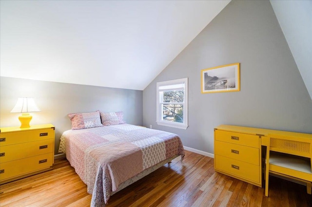 bedroom with lofted ceiling and light hardwood / wood-style floors