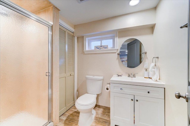 bathroom featuring a shower with door, vanity, wood-type flooring, and toilet