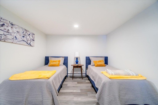 bedroom featuring light hardwood / wood-style floors and baseboard heating