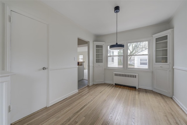 unfurnished dining area with radiator heating unit and light hardwood / wood-style flooring