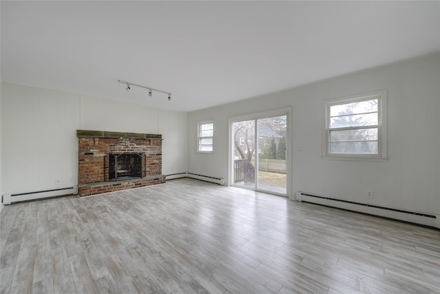 unfurnished living room with a fireplace, light hardwood / wood-style floors, and baseboard heating