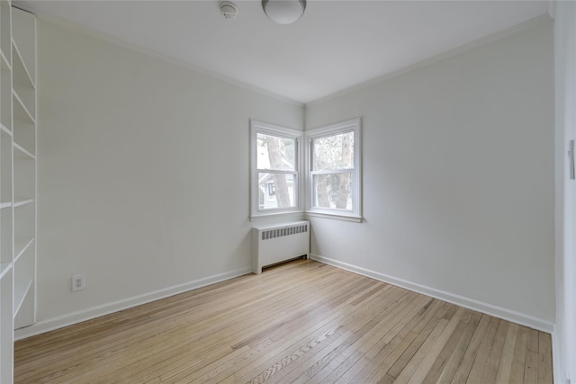 spare room featuring crown molding, radiator, and light hardwood / wood-style flooring