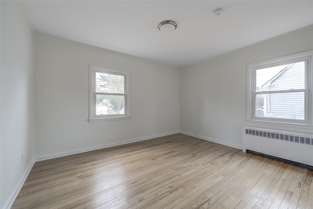 spare room with light hardwood / wood-style flooring and radiator heating unit