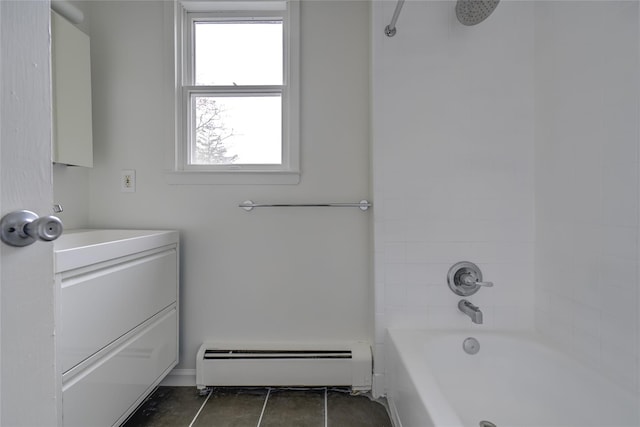 bathroom featuring vanity, tile patterned floors, baseboard heating, and tiled shower / bath