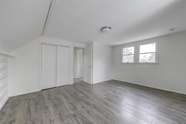 bonus room with hardwood / wood-style floors and vaulted ceiling