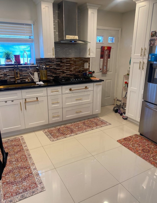 kitchen with white cabinetry, black gas stovetop, and wall chimney exhaust hood