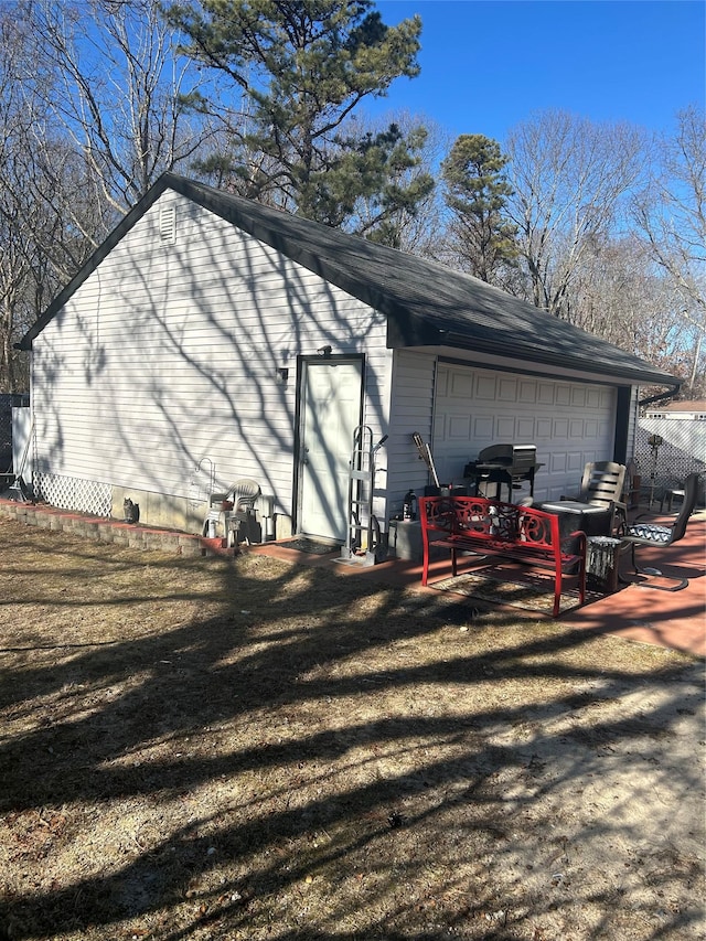 view of side of home featuring an outbuilding, a garage, and a lawn