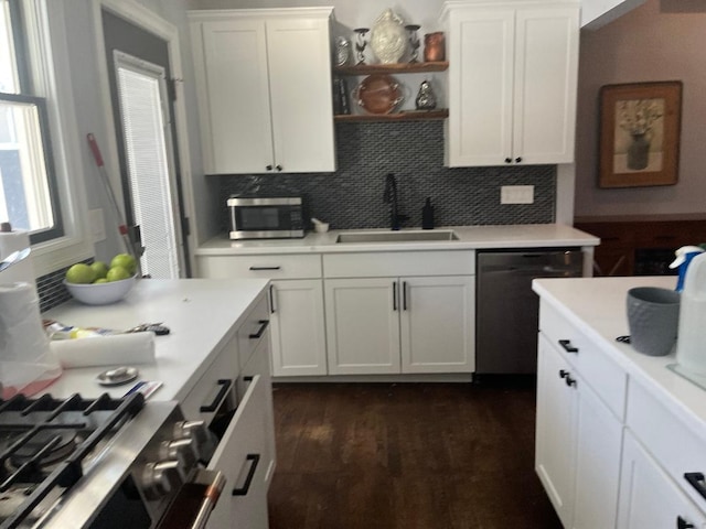 kitchen featuring sink, tasteful backsplash, appliances with stainless steel finishes, dark hardwood / wood-style floors, and white cabinets