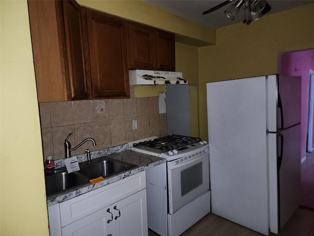 kitchen featuring sink, tasteful backsplash, ceiling fan, white appliances, and white cabinets