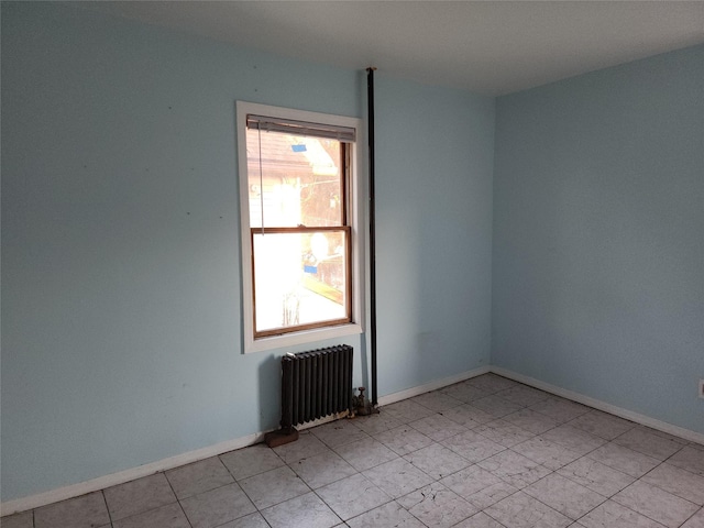 empty room featuring radiator heating unit and plenty of natural light