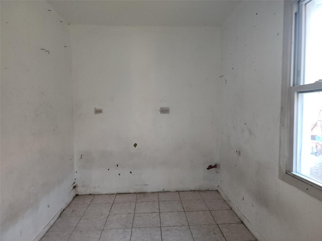 clothes washing area featuring light tile patterned floors