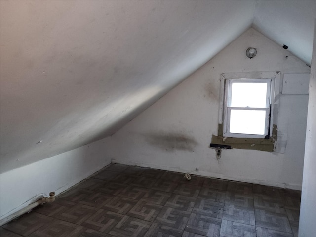 bonus room with lofted ceiling and dark parquet floors