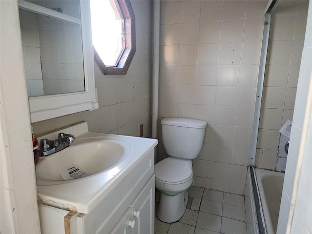 bathroom with toilet, tile walls, vanity, a bathing tub, and tile patterned flooring