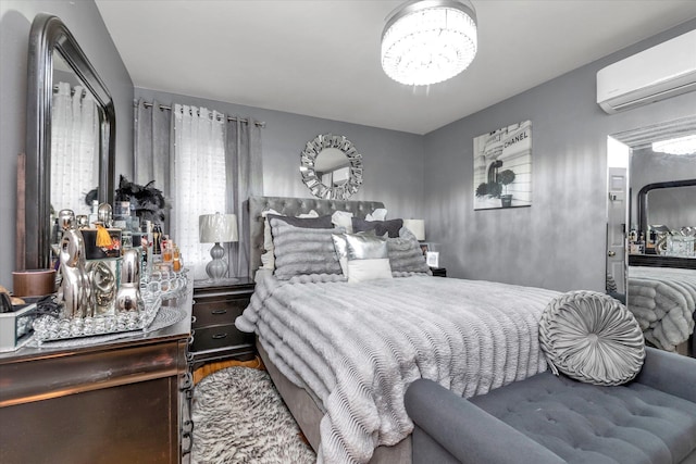 bedroom featuring wood-type flooring, an AC wall unit, and a notable chandelier