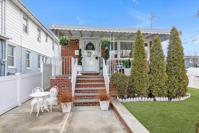 doorway to property with a yard and a patio