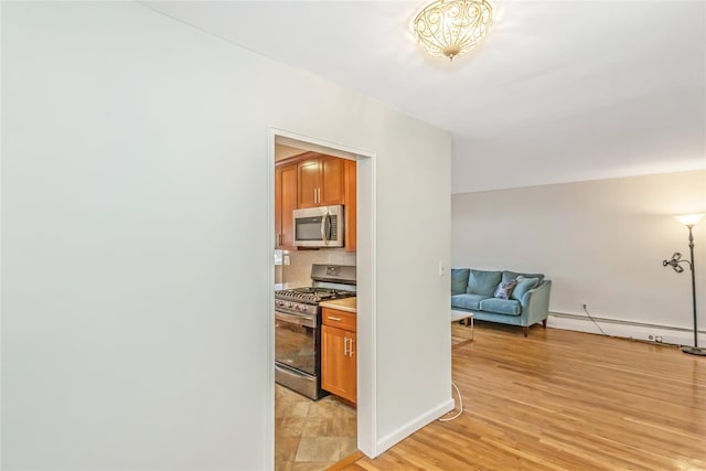 corridor featuring baseboard heating and light hardwood / wood-style flooring