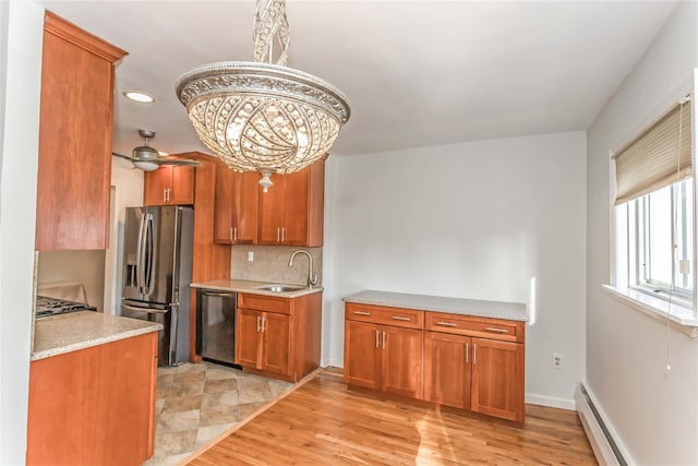 kitchen featuring sink, light wood-type flooring, a baseboard radiator, stainless steel appliances, and decorative backsplash