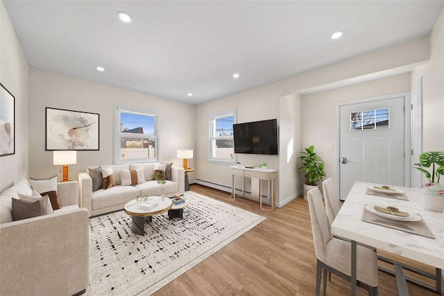 living room featuring a baseboard heating unit and light hardwood / wood-style floors