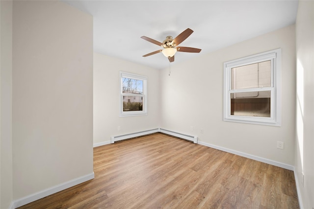 unfurnished room featuring ceiling fan, a baseboard heating unit, and light wood-type flooring