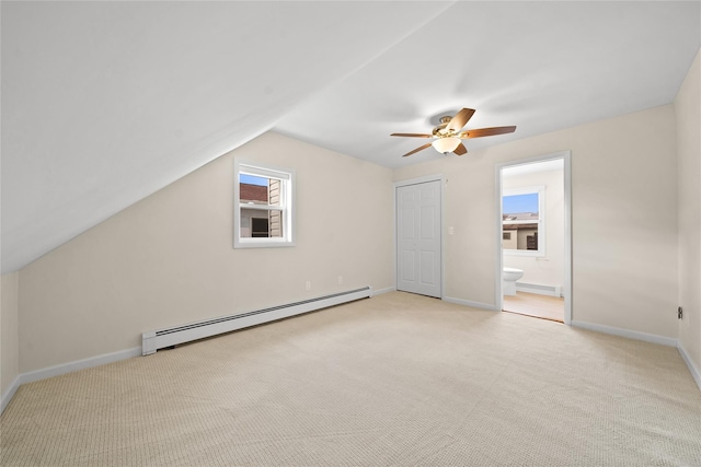 additional living space with lofted ceiling, light carpet, and a baseboard heating unit