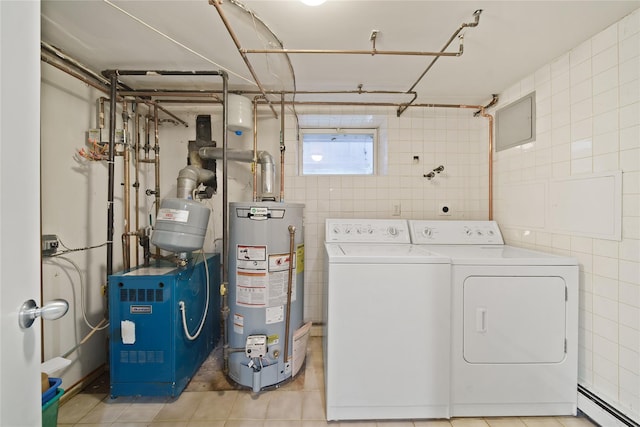 clothes washing area with water heater, separate washer and dryer, a baseboard heating unit, and tile walls