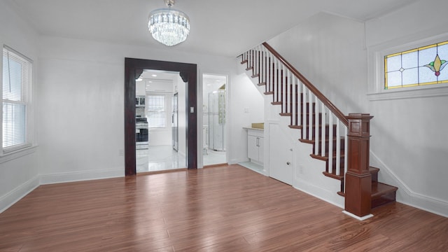 entrance foyer featuring a wealth of natural light, hardwood / wood-style floors, and a chandelier