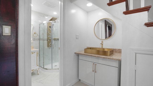 bathroom with a shower with door and vanity