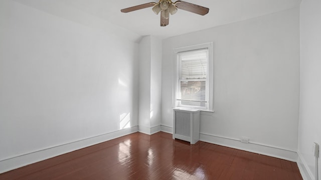 spare room featuring ceiling fan, radiator, and dark hardwood / wood-style flooring