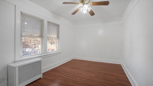 spare room with dark hardwood / wood-style flooring, radiator heating unit, and ceiling fan