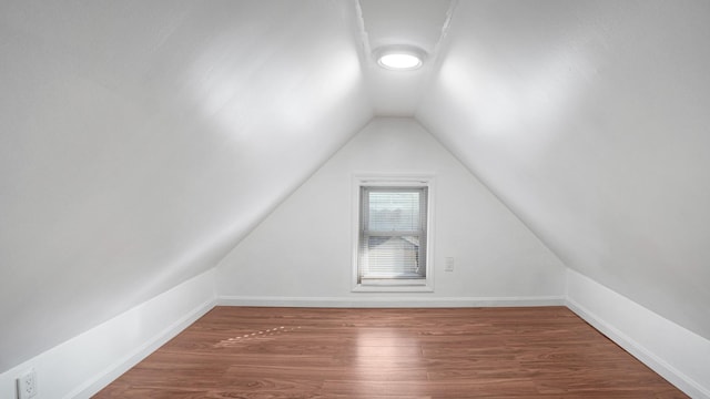 additional living space featuring vaulted ceiling and dark hardwood / wood-style floors