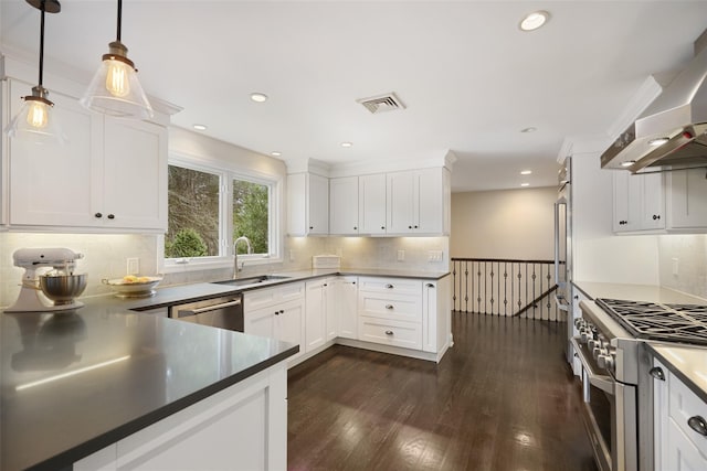 kitchen with visible vents, appliances with stainless steel finishes, dark wood-style floors, wall chimney exhaust hood, and a sink