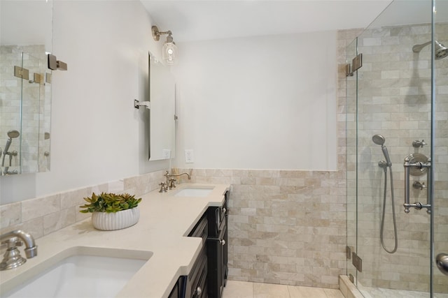 bathroom with double vanity, a stall shower, and a sink