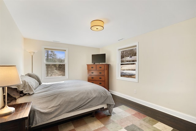 bedroom featuring visible vents, baseboards, and wood finished floors