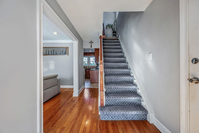 staircase featuring crown molding and hardwood / wood-style floors