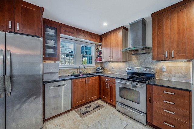 kitchen featuring appliances with stainless steel finishes, sink, decorative backsplash, and wall chimney range hood