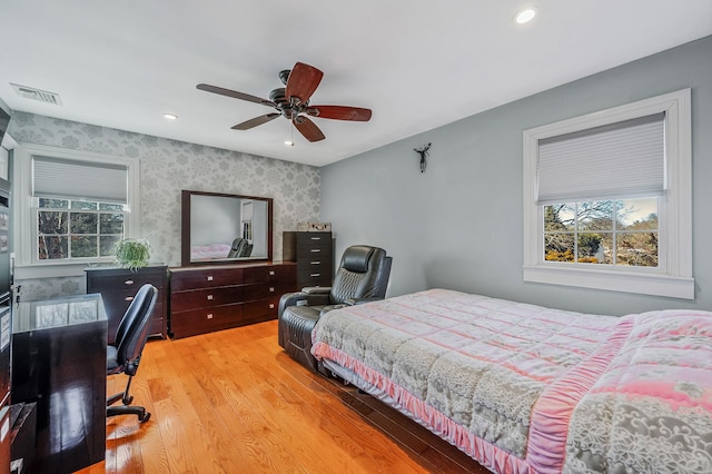 bedroom with multiple windows, ceiling fan, and light hardwood / wood-style flooring