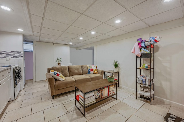 living room with a paneled ceiling and light tile patterned floors