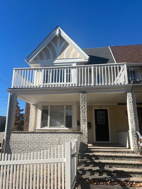 view of front of property with a balcony and covered porch