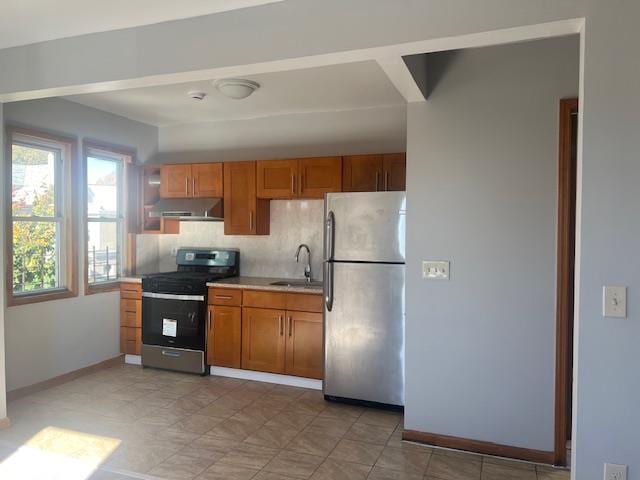 kitchen with tasteful backsplash, appliances with stainless steel finishes, sink, and exhaust hood